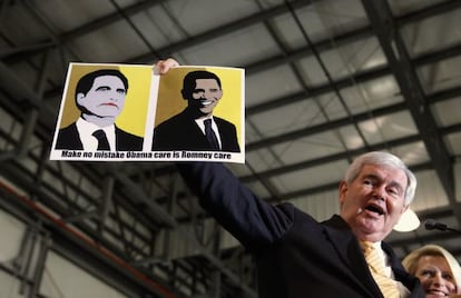Newt Gingrich muestra una pancarta que equipara las reformas sanitarias de Romney y Obama durante un mítin en Florida. 