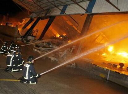 Los bomberos atacan las llamas en la nave de O Gorxal durante la madrugada de ayer.