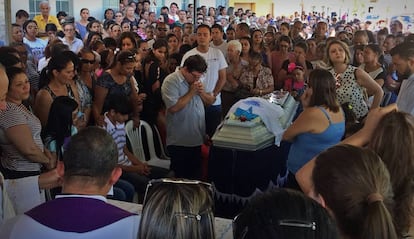 Marido faz preces diante do caixão de Heley durante o velório.