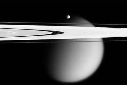 Imagen de dos de los satélites de Saturno: Titán (el grande) y Epimeteo (pequeño, en el centro). En primer plano, los anillos del planeta. Foto tomada por la sonda <i>Cassini</i> el 28 de abril de 2006.