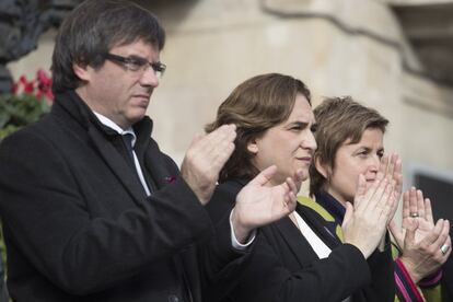 El presidente de la Generalitat de Cataluña, Carles Puigdemont, y la alcaldeda de Barcelona, Ada Colau, aplauden después del minuto de silencio en el Día Internacional contra la Violencia de Género.
