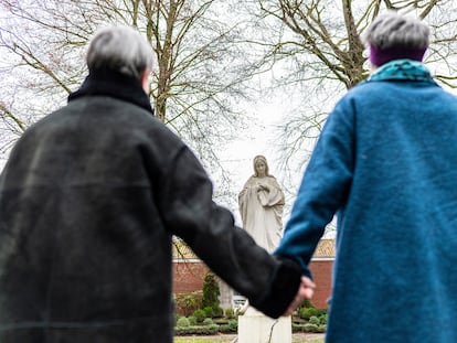 Dos mujeres se dan la mano hoy frente a una imagen de la Virgen María en el el convento de Lüdinghausen, (Alemania).