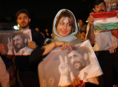 Una seguidora del presidente Ahmadineyad porta un cartel con su imagen en las calles de Teherán