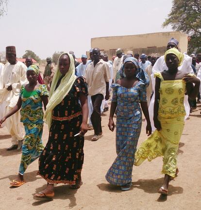 In this Monday April 21, 2014 file photo, four female students of the government secondary school Chibok, who were abducted by gunmen and reunited with their families, walk in Chibok, Nigeria. A civil society group says Wednesday April 30, 2014, that villagers are reporting that scores of girls and young women who were recently kidnapped from a school in Nigeria are being forced to marry Islamic extremists. A federal senator for the area in northeast Nigeria wants the government to get international help to rescue the more than 200 missing girls kidnapped by Boko Haram from a school two weeks ago. (AP Photo/ Haruna Umar, File)