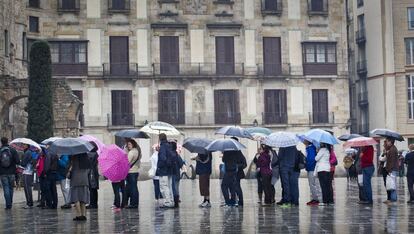 Turistas paseando por Barcelona durante una lluviosa jornada de vacaciones de Semana Santa.