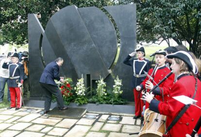 El alcalde de Bilbao, Iñaki Azkuna, deposita unas flores sobre el monumento Memoria viva durante el acto.