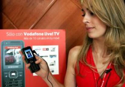 Una responsable de Vodafone España muestra un teléfono durante la presentación de la primera programación completa de televisión en el móvil. EFE/Archivo