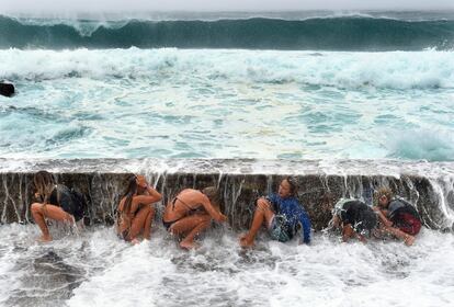 Jóvenes disfrutan con las fuertes olas que llegan a la costa en Gold Coast, Queensland (Australia).