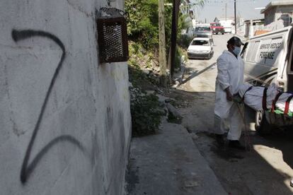 Forensics remove a body from a crime scene in Monterrey.