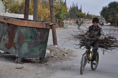 Un chico porta madera en el este de Ghouta.