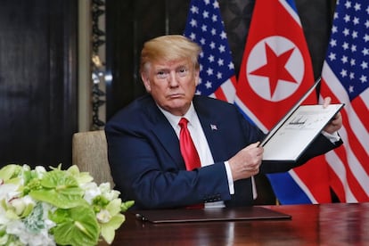 El presidente Donald Trump sostiene el documento firmado por él y por Kim Jong-un.