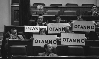 Diputados de Izquierda Unida despliegan en el Congreso carteles contra la OTAN mientras Julio Anguita (izquierda) habla por teléfono, en 1997.