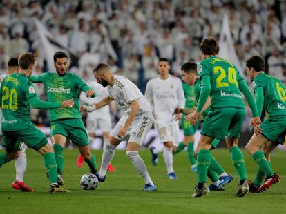 Benzema controla el balón entre varios jugadores de la Real Sociedad.