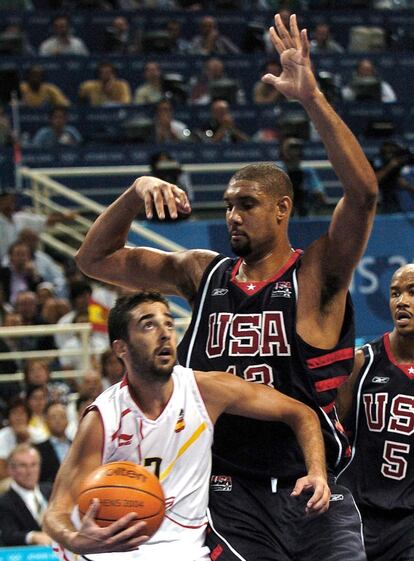 Juan Carlos Navarro lucha bajo el aro con el estadounidense Tim Duncan, durante el partido de cuartos de final del torneo de baloncesto de los Juegos Olímpicos de Atenas 2004.