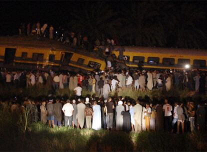 Centenares de personas observan el estado de los trenes que han chocado al sur de El Cairo.