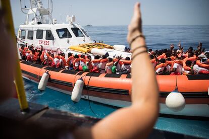 Un grupo de migrantes sube a bordo de una embarcación italiana.