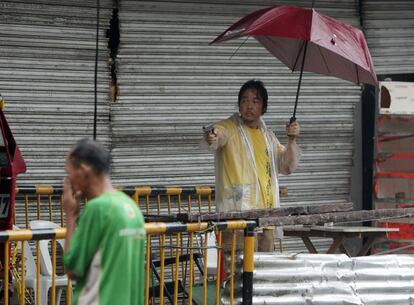 El dueño de una tienda amenaza con una pistola a los ladrones que intentan entrar en su tienda, en la ciudad de Tacloban, provincia de Leyte.