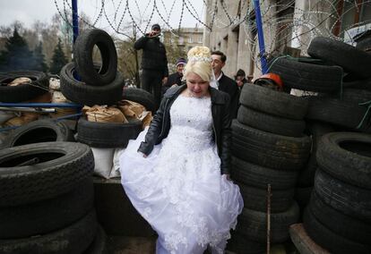 Unos novios visitan la barricada construida por los prorusos entorno al edificio del gobierno regional de Donetsk, en el este de Ucrania.