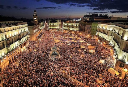 Miles de personas abarrotan el <i>kilómetro cero</i> en las concentraciones convocadas a las ocho de la tarde. Jóvenes, ancianos y familias acuden a expresar su indignación pese a la prohibición de la Junta Electoral. "Que no nos representan" es el grito más repetido.