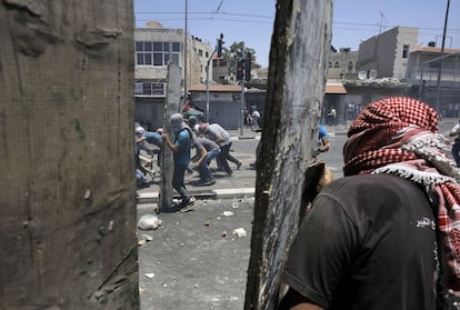 Jóvenes palestinos lanzan piedras a las fuerzas de seguridad israelíes.