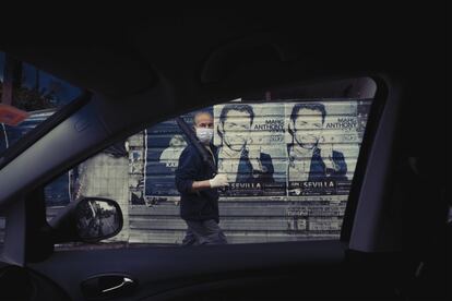 Un hombre pasa por delante de unos carteles publicitarios en el vallado de un solar del barrio de Bami, el 15 de abril.