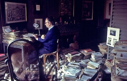 Joan Brossa, en la ja mítica habitació, envoltat de llibres i papers.