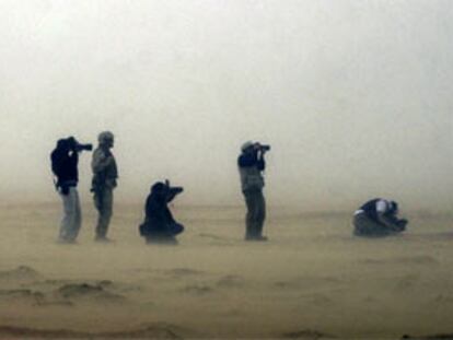 Varios fotógrafos de prensa y <b><i>marines</b></i> estadounidenses, durante una tormenta de arena en el desierto de Kuwait.
