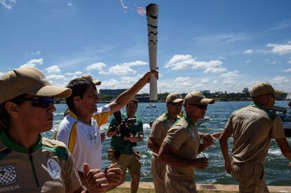 El triatleta Leandro Macedo lleva la llama olímpica a lo largo del lago Paranoá en Brasilia.