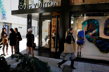 Gente paseando frente a una tienda de Louis Vuitton en Miami.