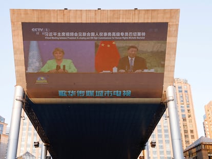 La alta comisionada de la ONU, Michelle Bachelet, y el presidente chino Xi Jinping durante un encuentro virtual televisado en un centro comercial de Pekín.