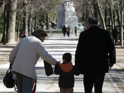 Unos abuelos acompa&ntilde;an a su nieto en el parque de El Retiro de Madrid. 