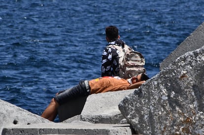 Dos jóvenes reposan en uno de los espigones del puerto de La Puntilla en Ceuta el pasado 22 de mayo.