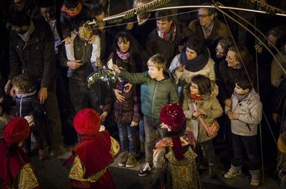 Un niño entrega su carta a un paje durante la cabalgata de Barcelona.