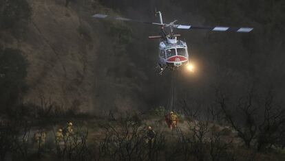 Las luces de un helicóptero iluminan el lugar de aterrizaje mientras la tripulación del 'Boggs Forest Cal Fire' se prepara para abordar, al este de Santa Rosa, en California (EE UU).