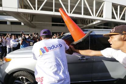 Simpatizantes de Nicolás Maduro intentan acercarse al automóvil del líder de la oposición en el aeropuerto de Caracas.