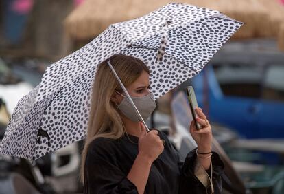 Una mujer pasea por el centro de Palma protegida con un paraguas.