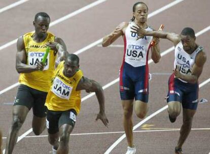 Tyson Gay, a la derecha, coge el testigo de Spearmon durante los relevos de 4x100. A la izquierda, el jamaicano Bolt lanza a Carter.