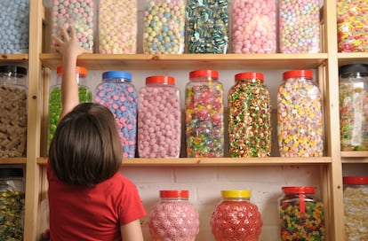 Una niña, en una tienda de dulces.