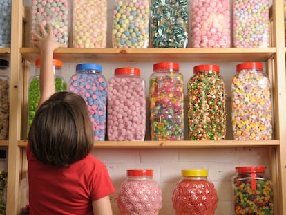 Una niña, en una tienda de dulces.