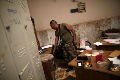 Un soldado del ejército iraquí inspecciona el escritorio de una habitación dentro del recinto empleado como prisión por el Estado Islámico.