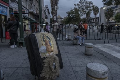 Visitantes a la basílica de Guadalupe esperan en el cerco de seguridad al encontrar la iglesia cerrada.