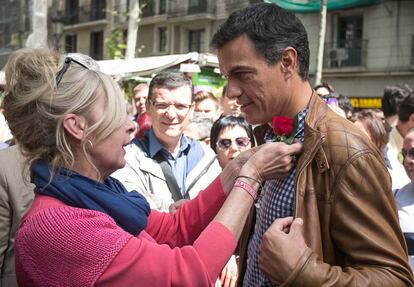 Una florista coloca una rosa a Pedro Sánchez.