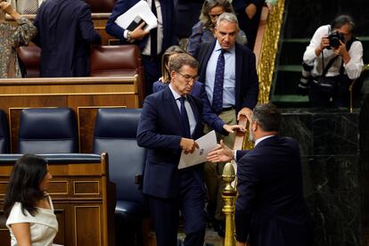 Santiago Abascal tiende la mano a Alberto Núñez Feijóo durante el pleno celebrado en el Congreso de los Diputados este martes.  