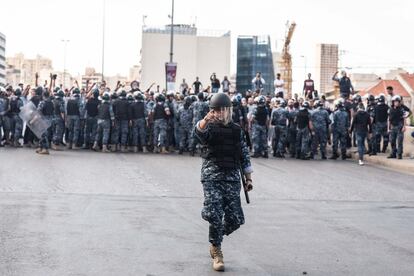 Policías antidisturbios libaneses se despliegan en la carretera de circunvalación de Beirut tras que un centenar de jóvenes afines a los partidos de Amal y Hezbolá atacaran a manifestantes que por 13 días consecutivos bloquean las principales arterias del país pidiendo la dimisión del Gobierno.