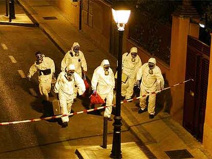 Técnicos con trajes de protección NBQ inspeccionan la calle en la que se produjo el escape de ácido cianhídrico.
