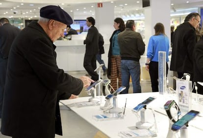 Un hombre prueba un teléfono móvil en una tienda de tecnología de El Corte Inglés de Bilbao