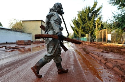 Un soldado húngaro, ataviado con un mono contra sustancias químicas, participa en las labores de limpieza de Devecser.