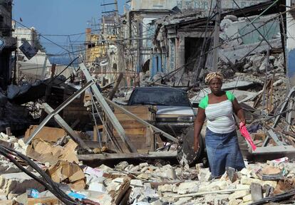 Se suceden los días y la capital de Haití sigue siendo una calle sin salida sepultada por un amasijo de escombros y vigas torcidas, donde una mujer trata de abrirse paso entre el olor dulzón a cadáver que golpea en cada esquina. 