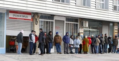 Varias personas forman una larga cola ante una oficina del INEM, a primera hora de la mañana.
