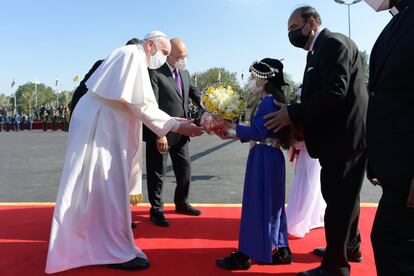 Una niña da la bienvenida al papa Francisco, entregándole un ramo de flores. En el centro, el presidente de Irak, Barham Salih. Francisco, sin embargo, consideraba inaplazable el viaje para llevar a cabo su cuidada política de encuentro entre campanarios y minaretes.
